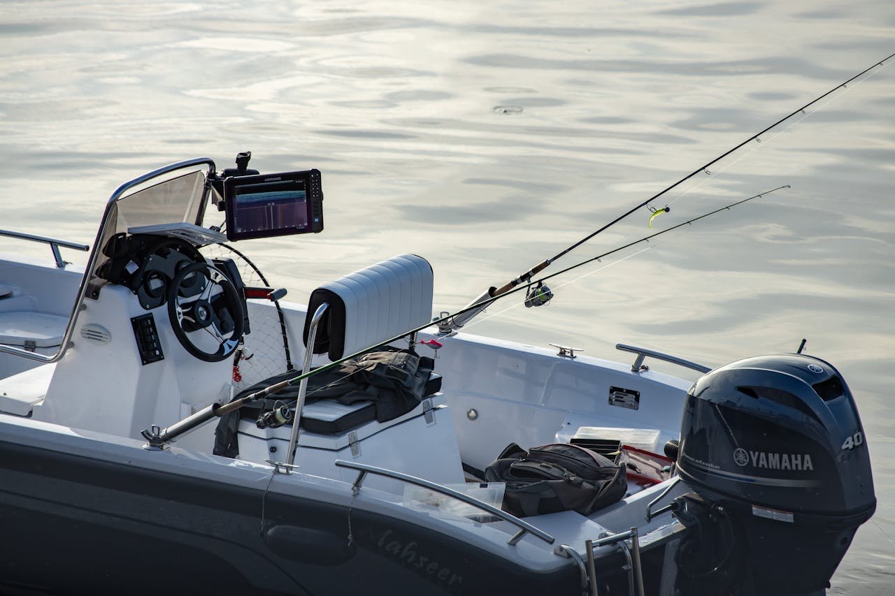 Home Close-up of a fishing motorboat with rods and equipment on calm water, ideal for leisure and outdoor adventure.