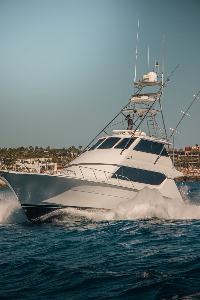 About A sleek motor yacht cruising through vibrant blue waters near Cabo San Lucas, Mexico.