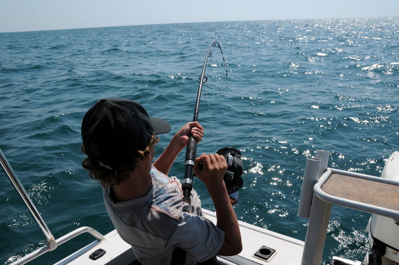 A young man actively fishing in the ocean near Broome, WA, enjoying a sunny day.